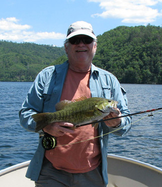 Frank Brown with a smallmouth bass he caught on a sunny day.